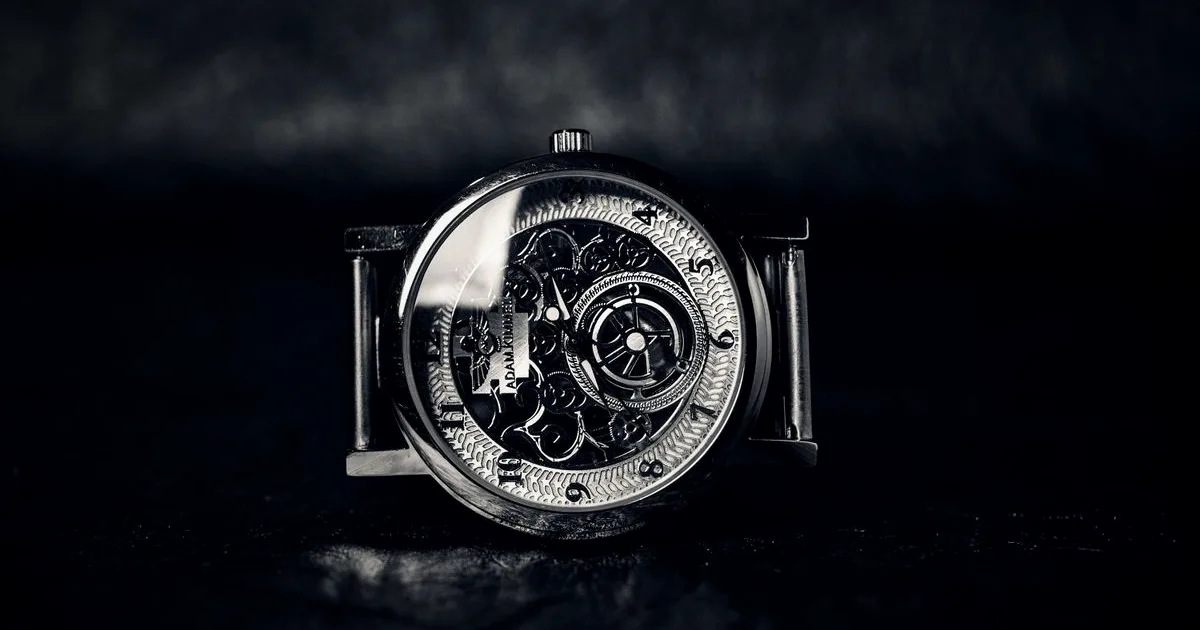 Luxury silver chronograph watch photographed against a dark, dramatic background